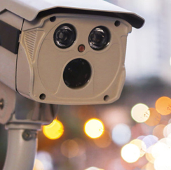 close up on a security camera with lights in the background