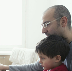 Father helping son with computer