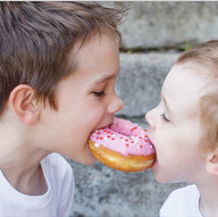 Boys eating same donut