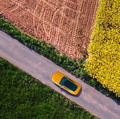 A sports car driving past fields