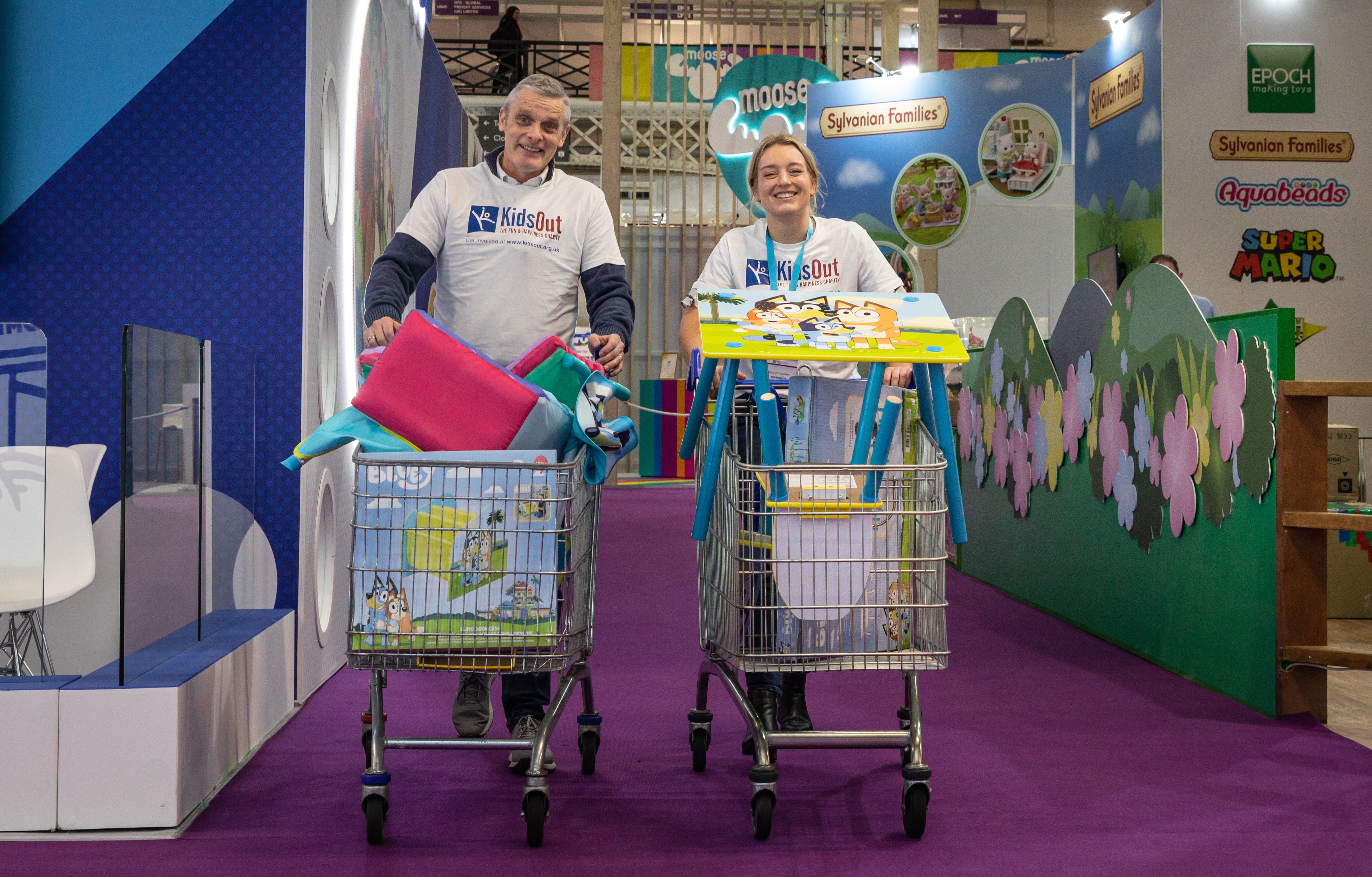 A man and a woman walking with shopping carts smiling 