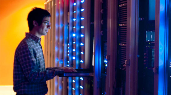Man standing in front of server with blue lights
