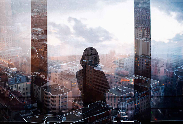 A woman looking at the view of the city from her window