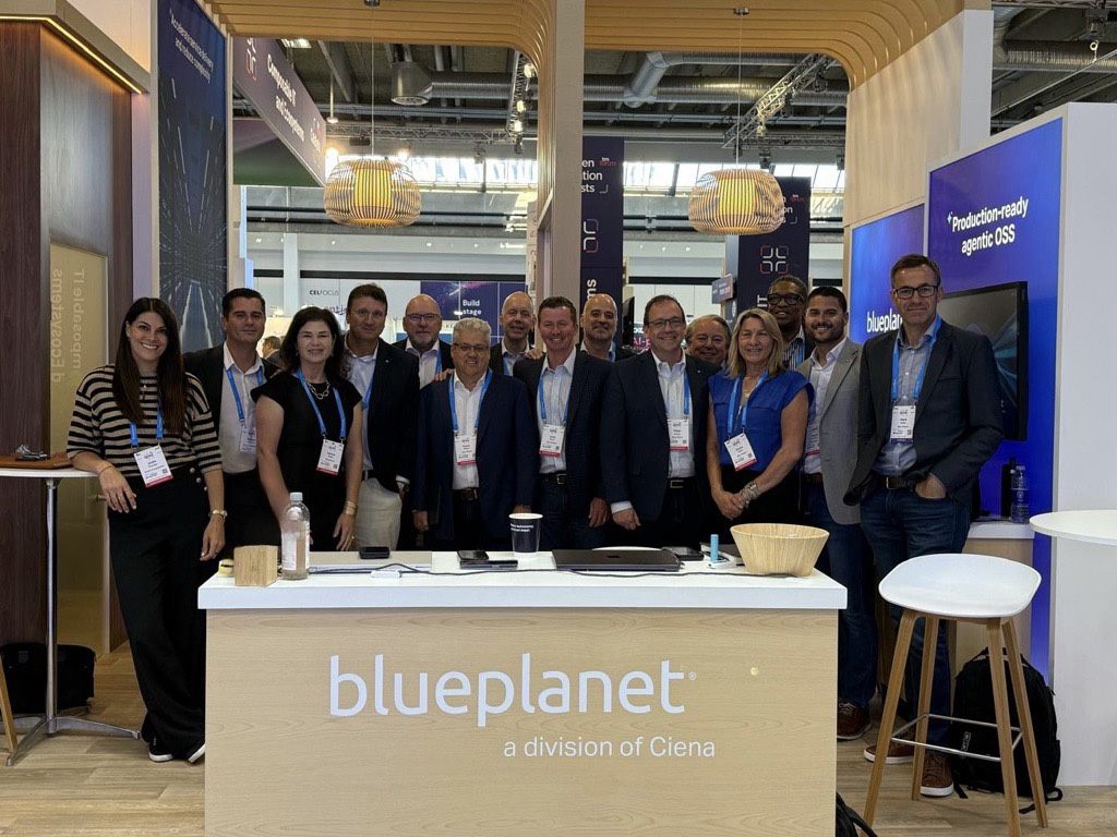 mosaic_DTW2 Group photo of Blue Planet team members and conference attendees gathered at the company booth during a technology industry event.