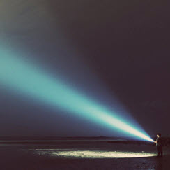 Boy+shining+flashlight+into+sky
