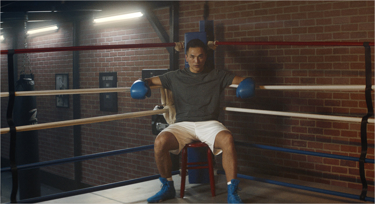 Man seating at the corner of a ring in the gym
