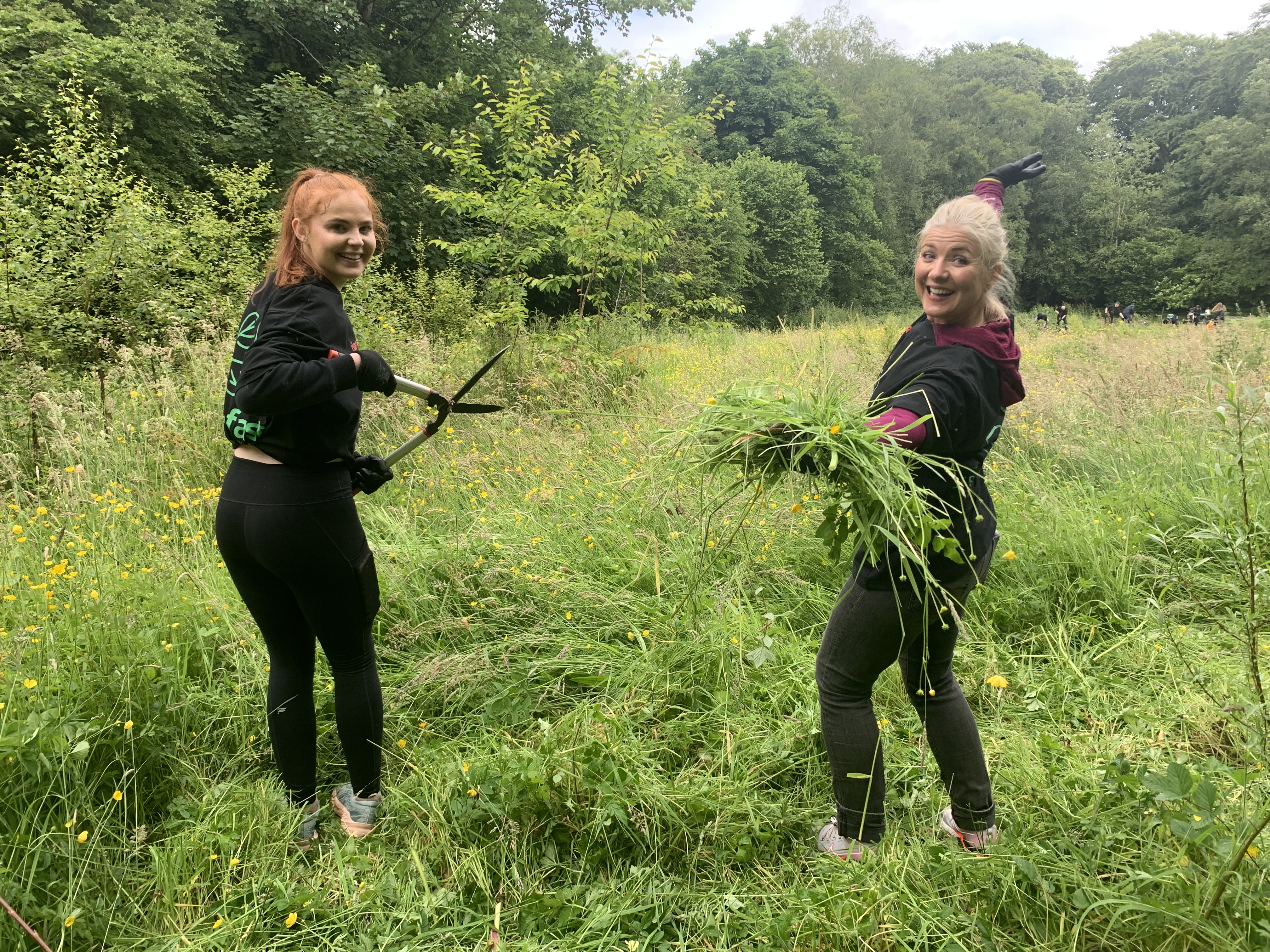 Lynne in a field with another Ciena employee volunteering to clean up the environment