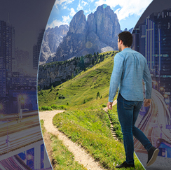 Man walking on path through fields and mountains