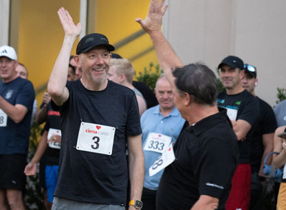 Two men giving each other a high five while others cheer in the background
