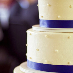 White wedding cake with navy blue ribbon