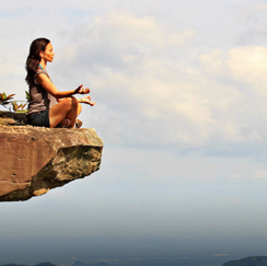 Women meditating on cliff