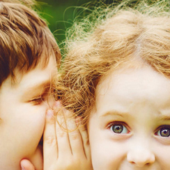 Boy whispering to girl