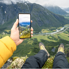 Man+taking+a+picture+of+valley+with+cell+phone