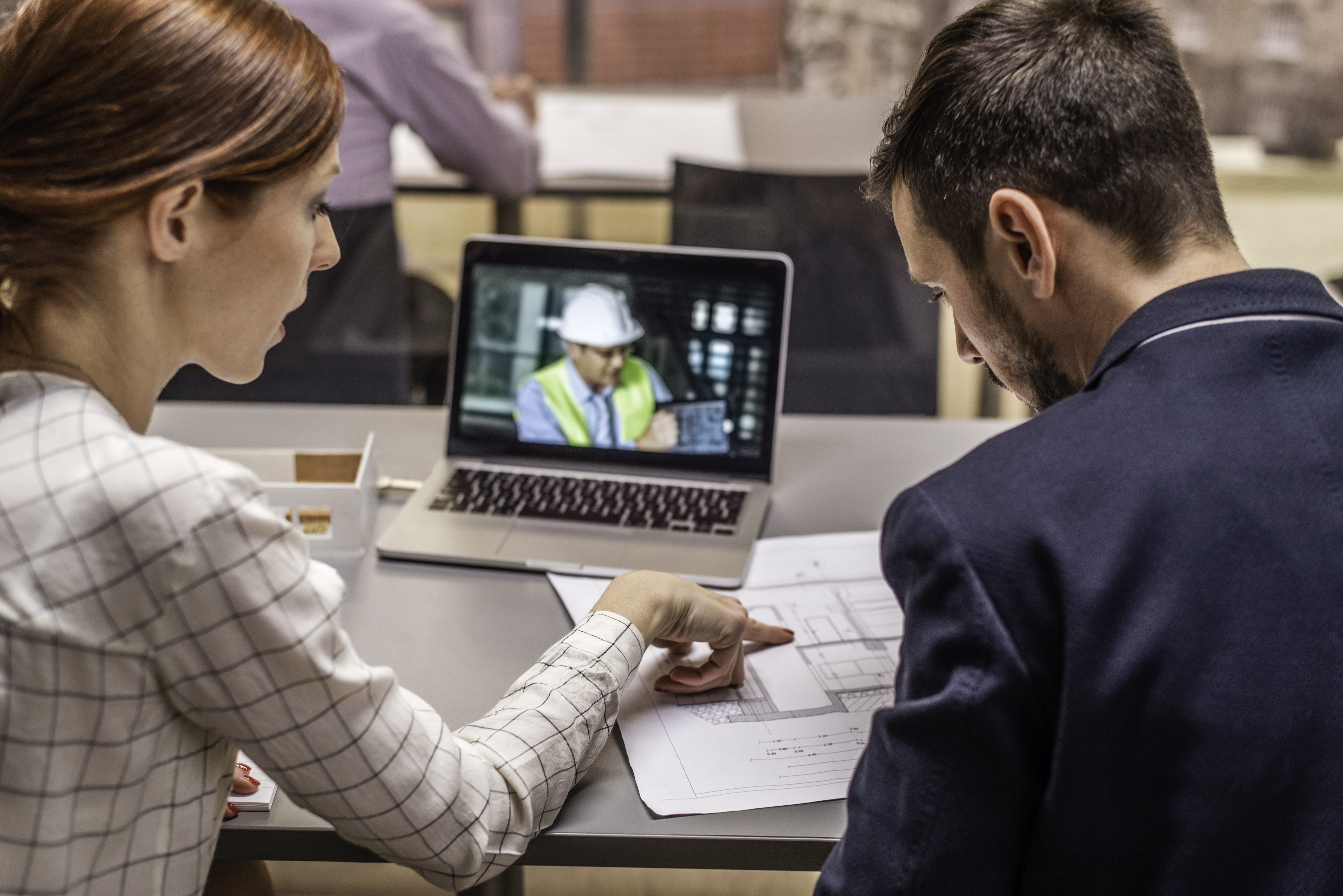 Two architects having video conference with an engineer colleague.