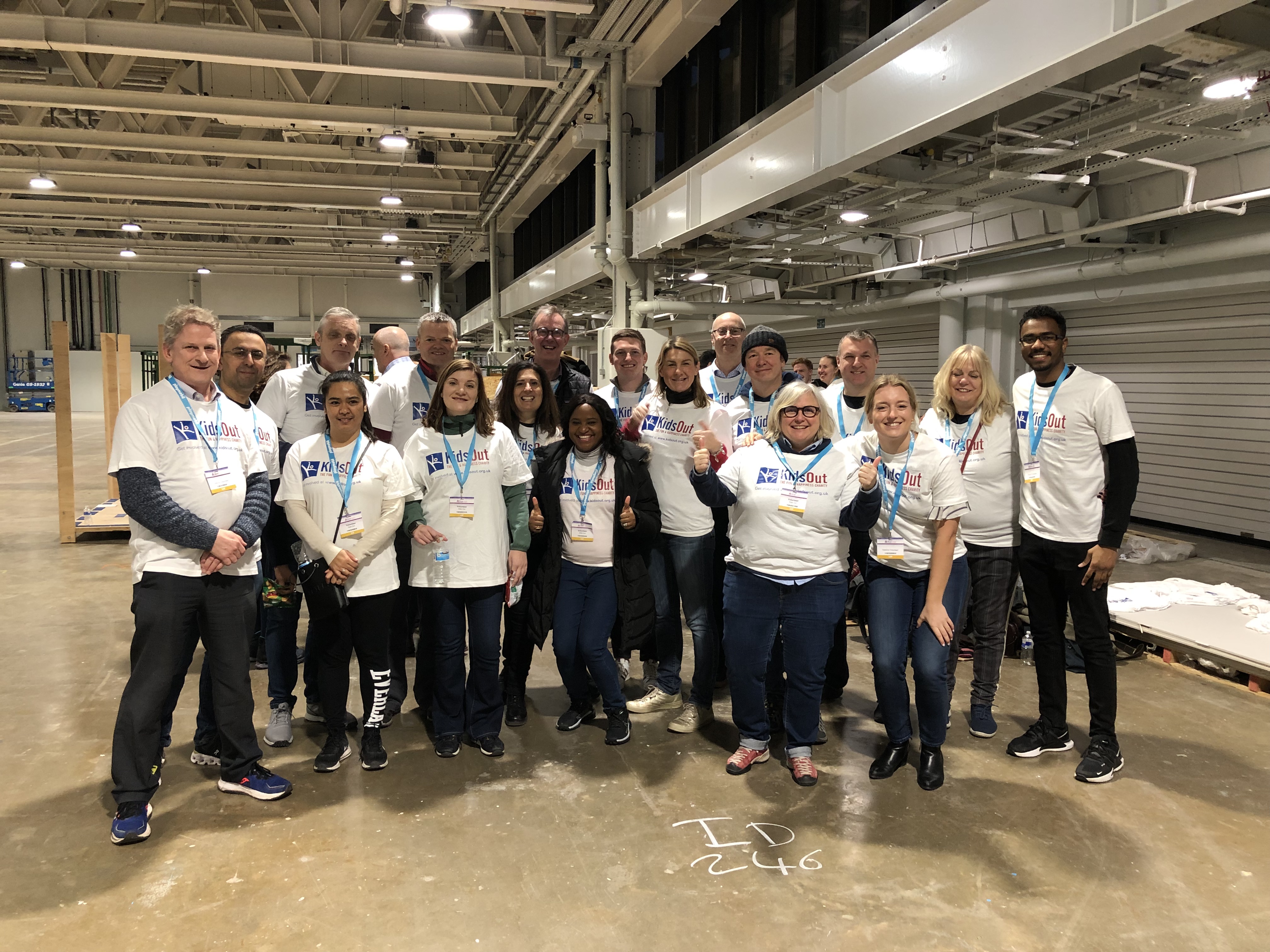 Group of men and women in matching white t-shirts smiling 