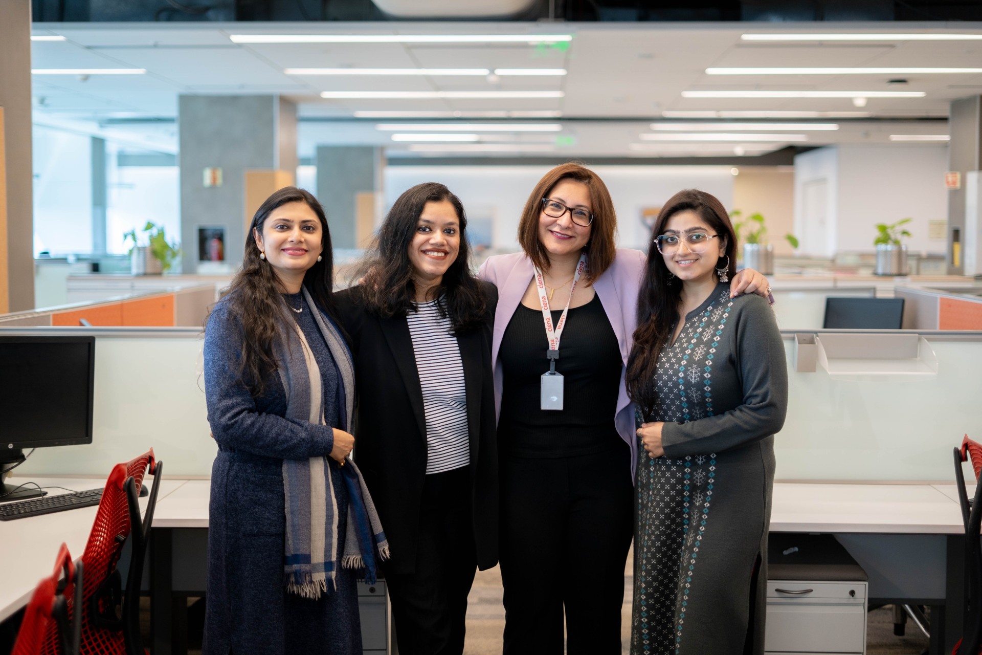 Four women posing together and smiling