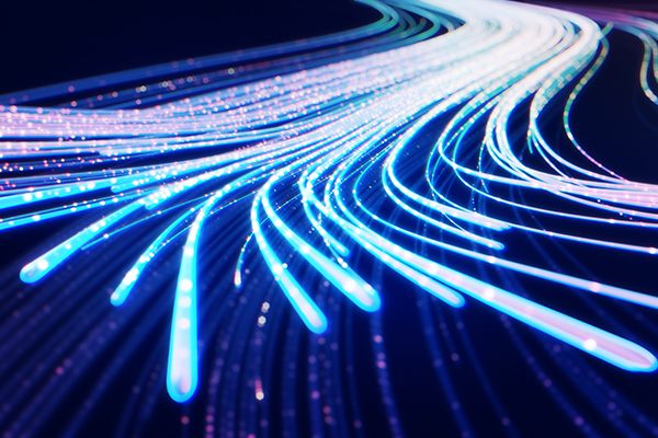 Abstract view of glowing blue and white optical fiber strands representing high-speed data transmission.