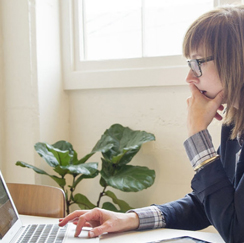 Woman with laptop and plant