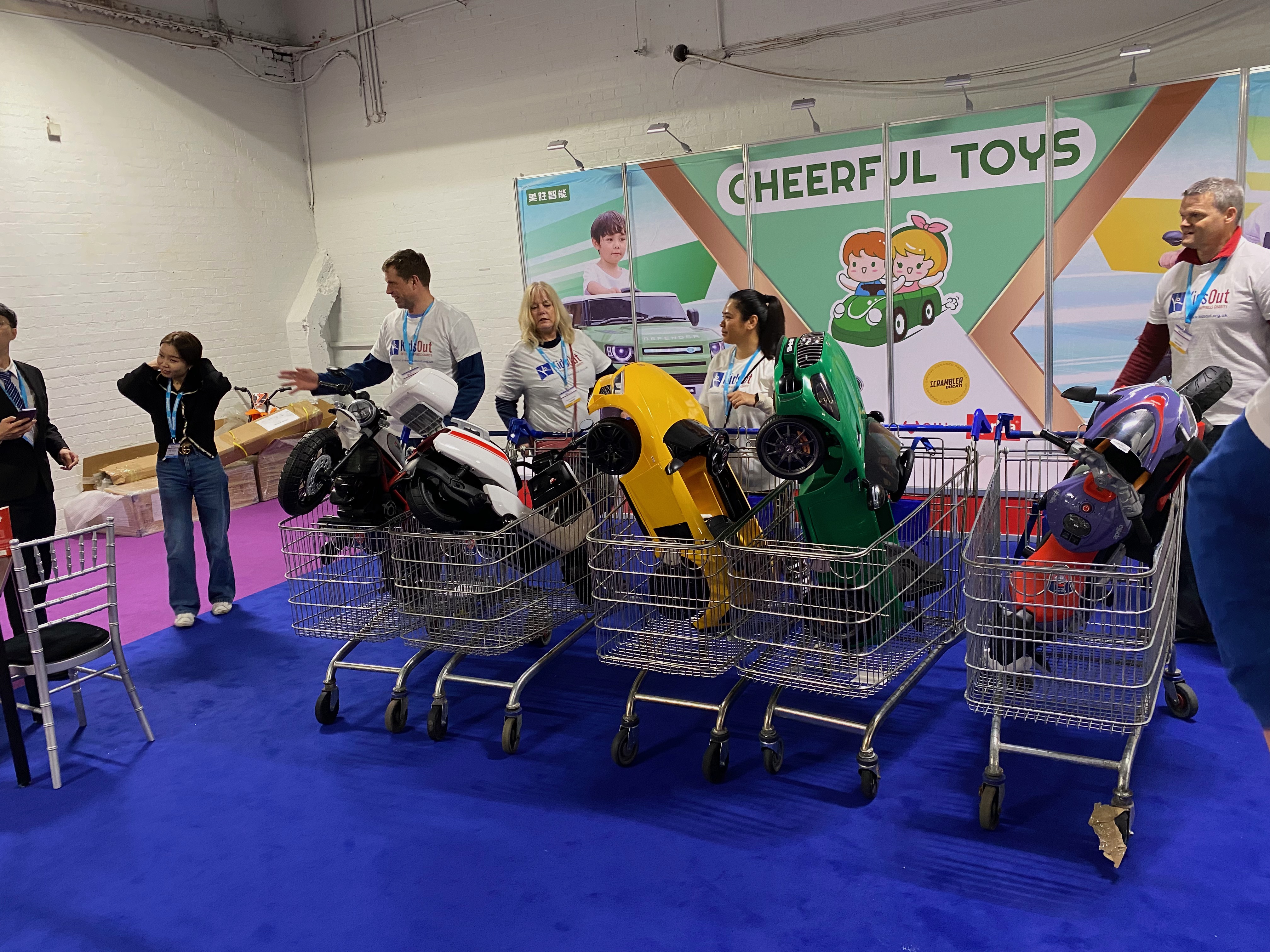 Men and women with shopping carts of toy moto bikes and cars