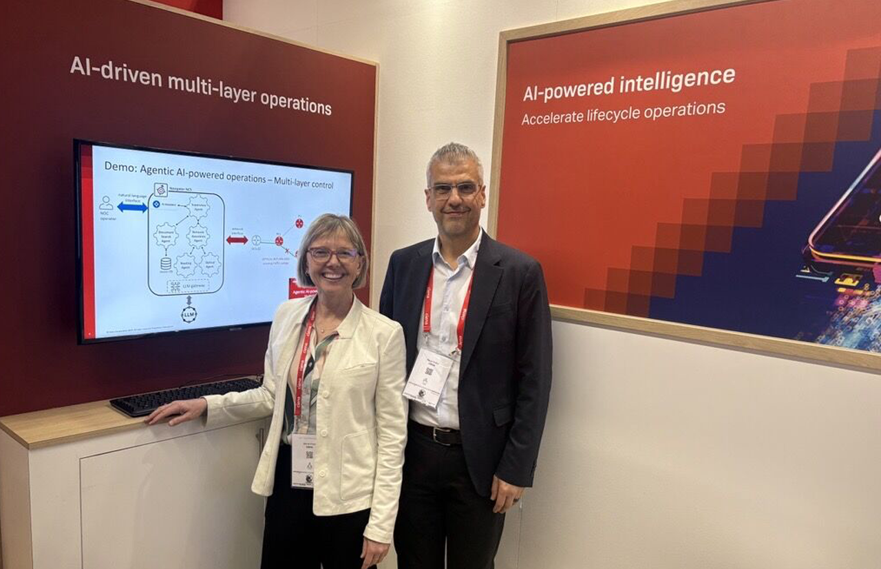 An exhibition booth showcasing AI-driven multi-layer operations and AI-powered lifecycle intelligence, with representatives presenting automation and network management solutions to visitors.