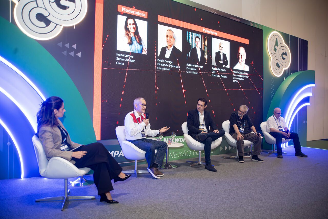 Several speakers seated on stage participating in a telecommunications or data-center discussion.