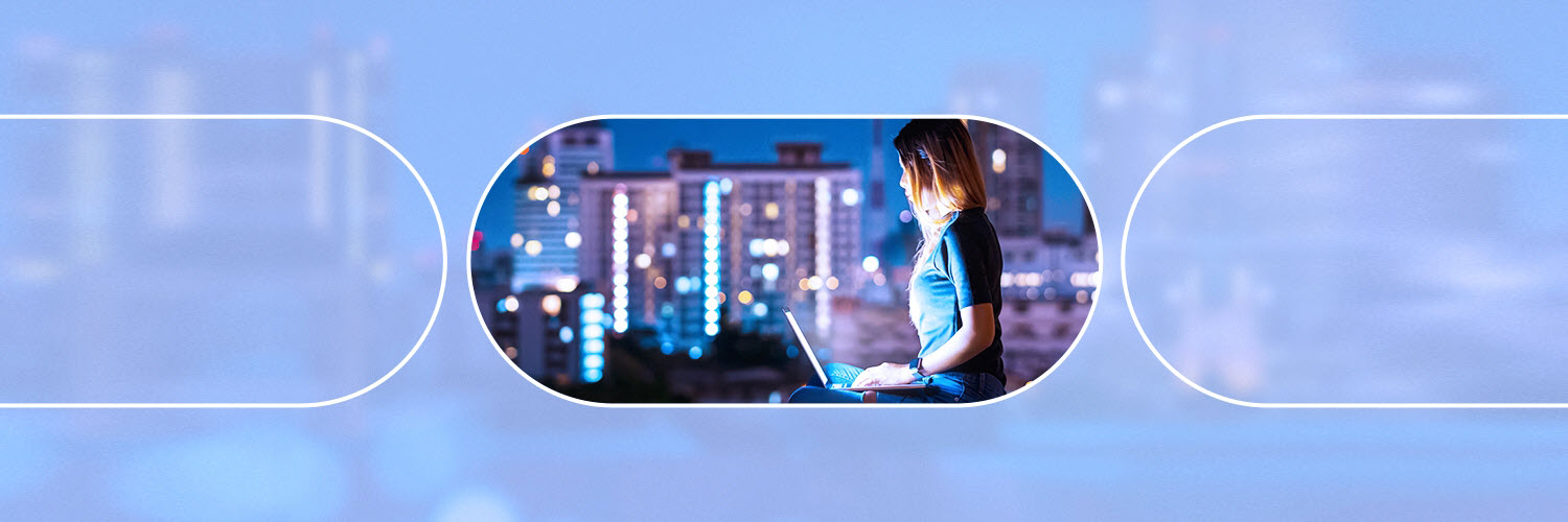 A woman infront of her laptop with the city scape