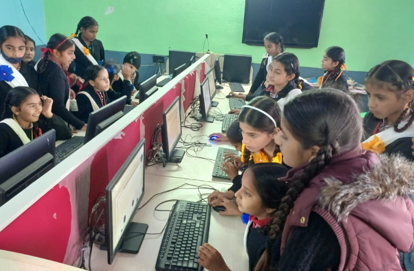 Students from India leaning on computers