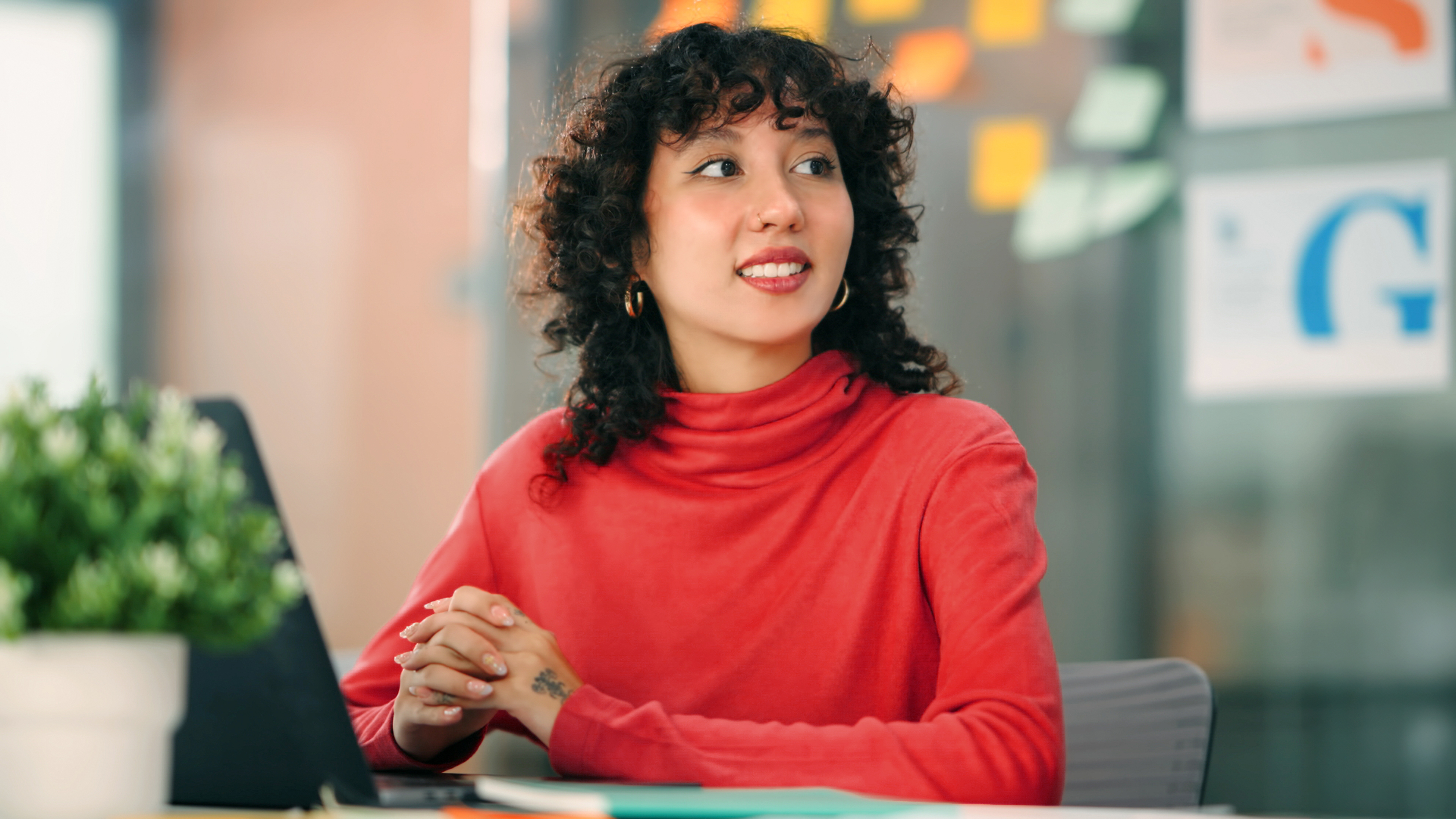 Woman in red sweater sitting in front of computer