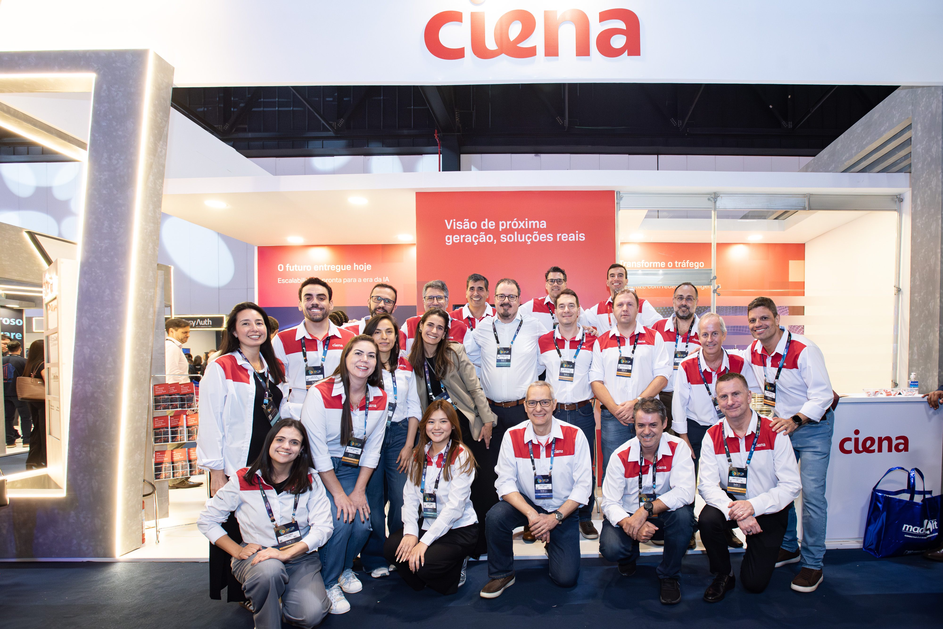 A larger group of staff members gathered in front of the Ciena booth.