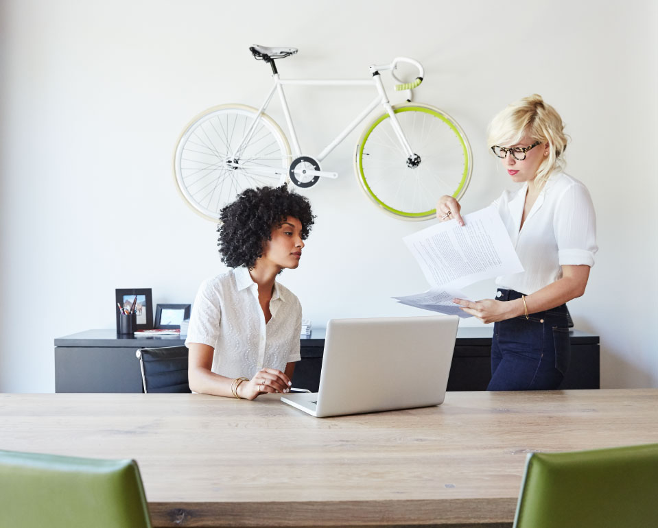 Image with women in office with bike on the wall