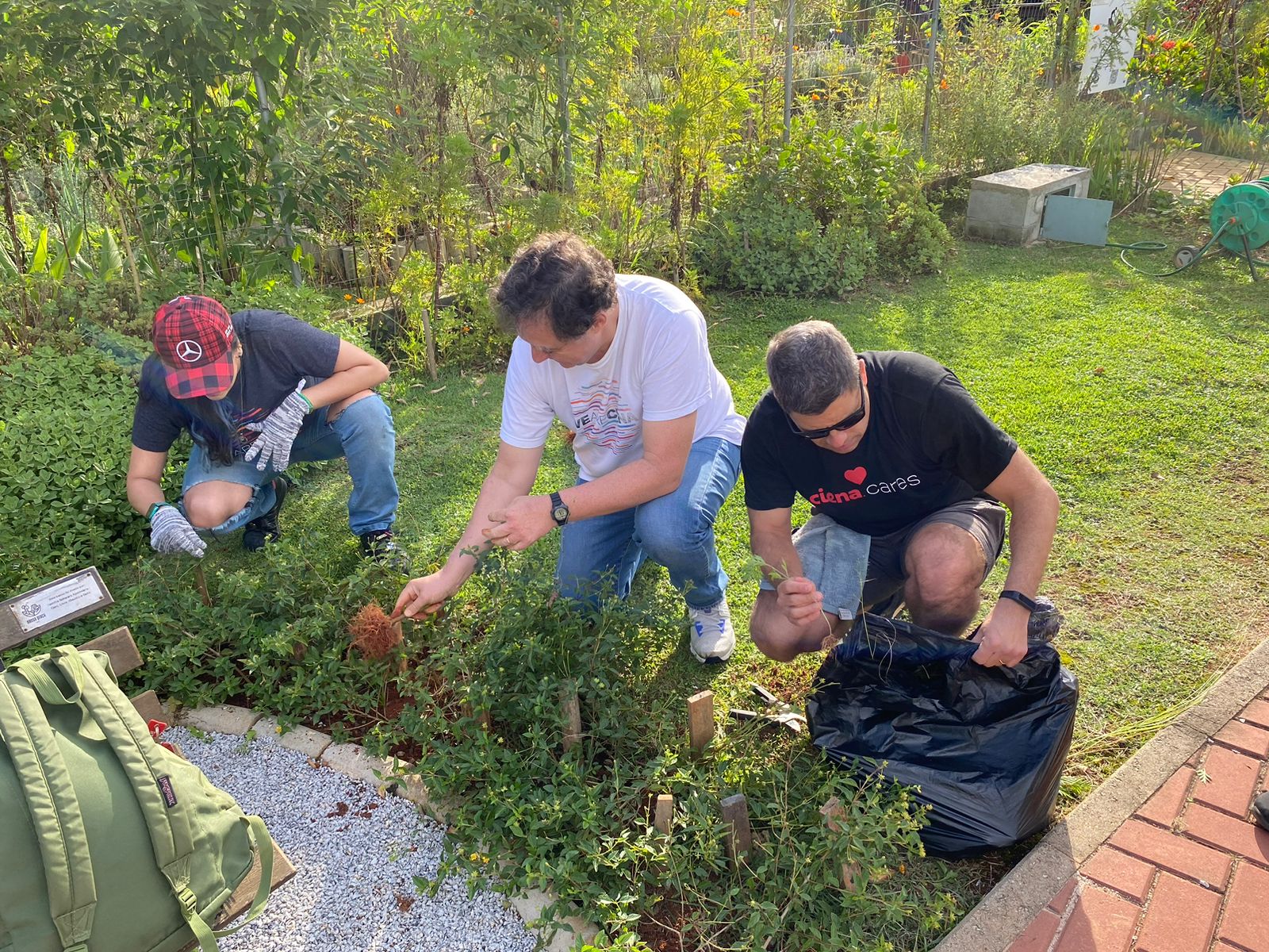 Men pulling weeds from a flowerbed