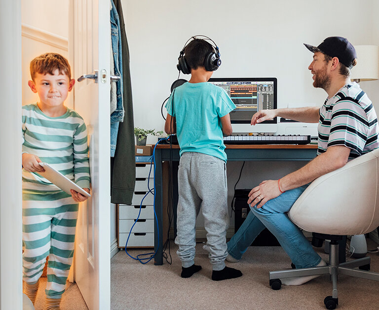 Dad with kids in front of a computer and a keyboard