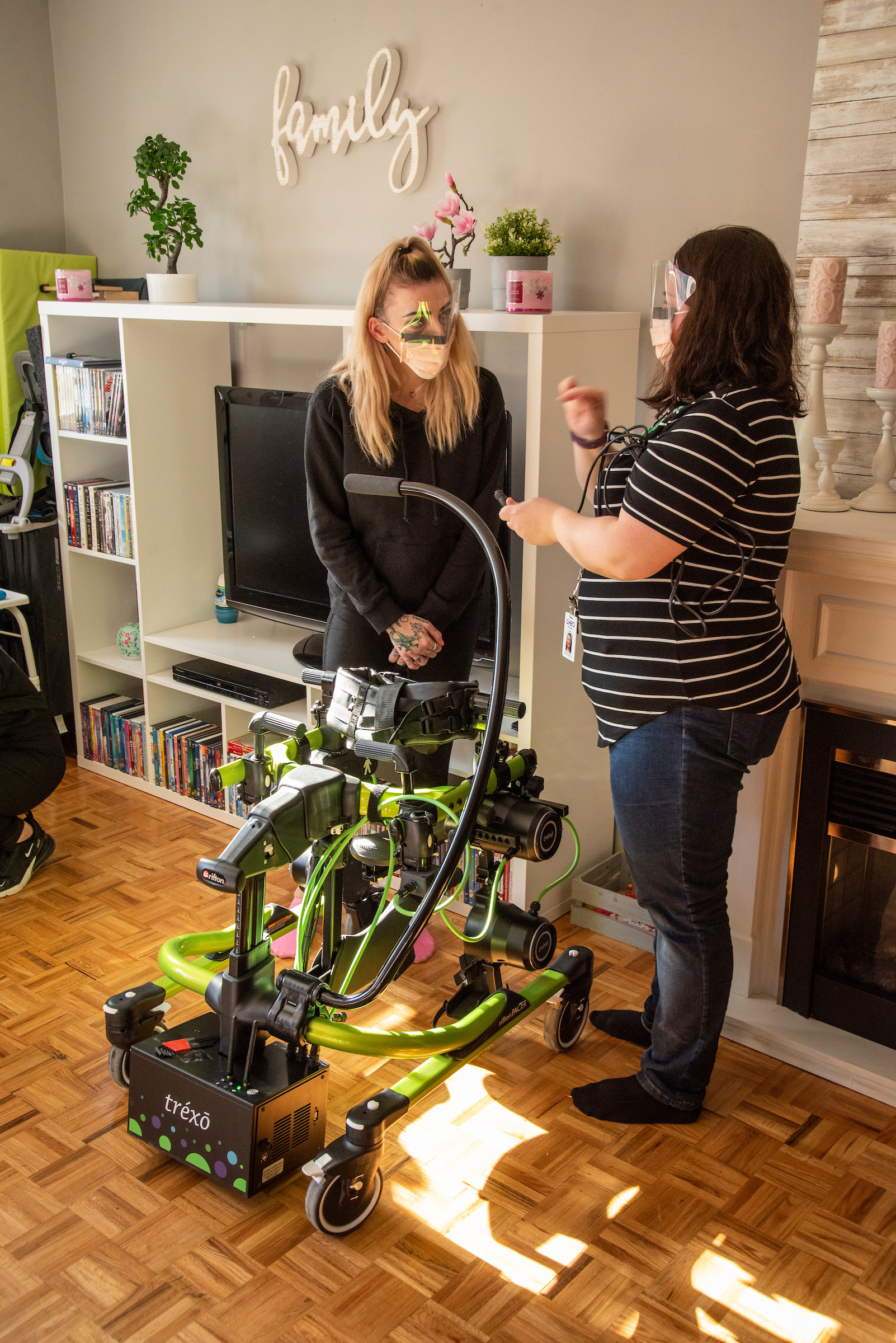 Two medical workers stand with robot walker