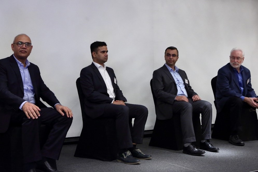 four men sitting in chairs on a stage