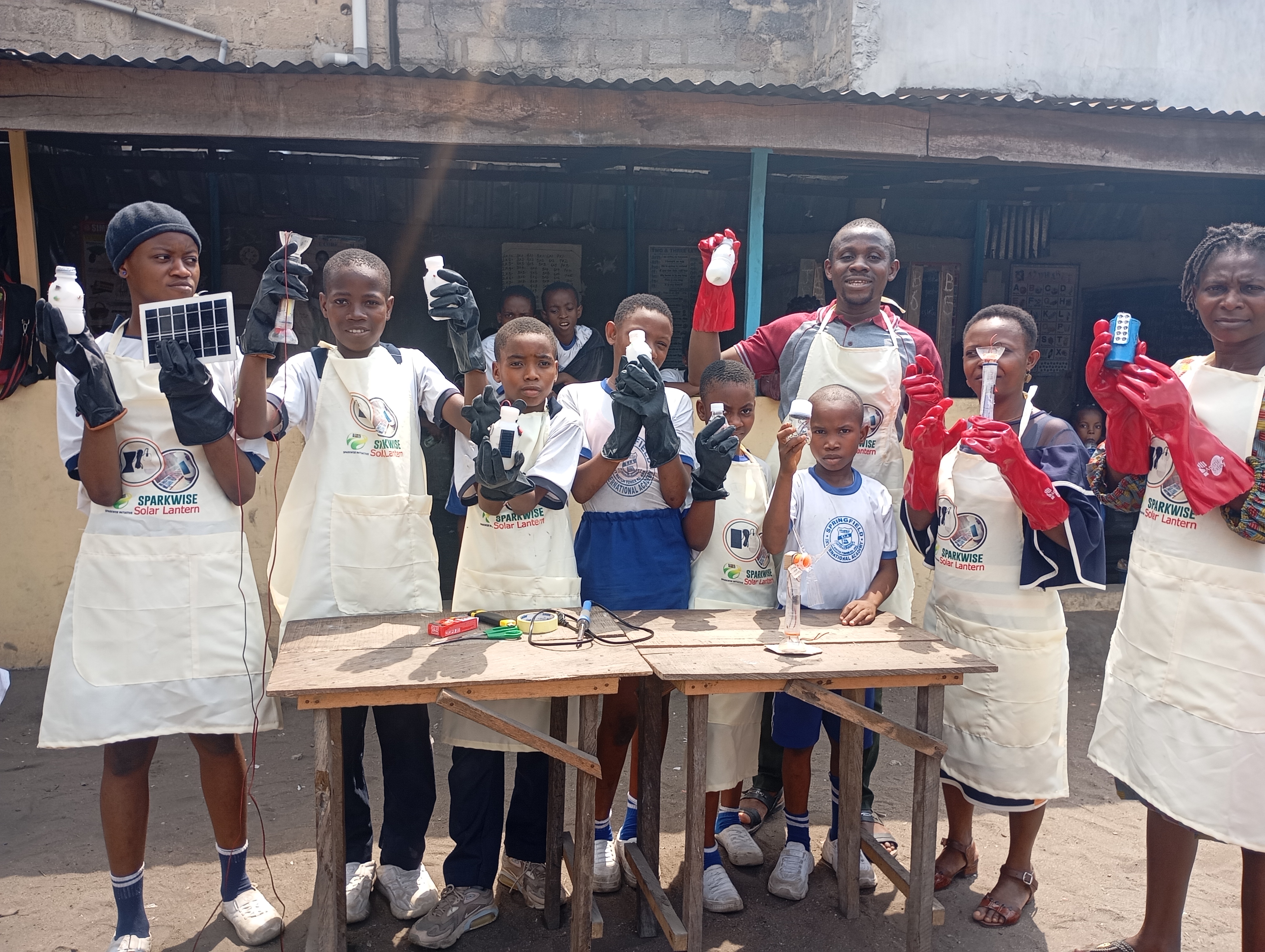 A group of students holding lab equipment at a table outdoors