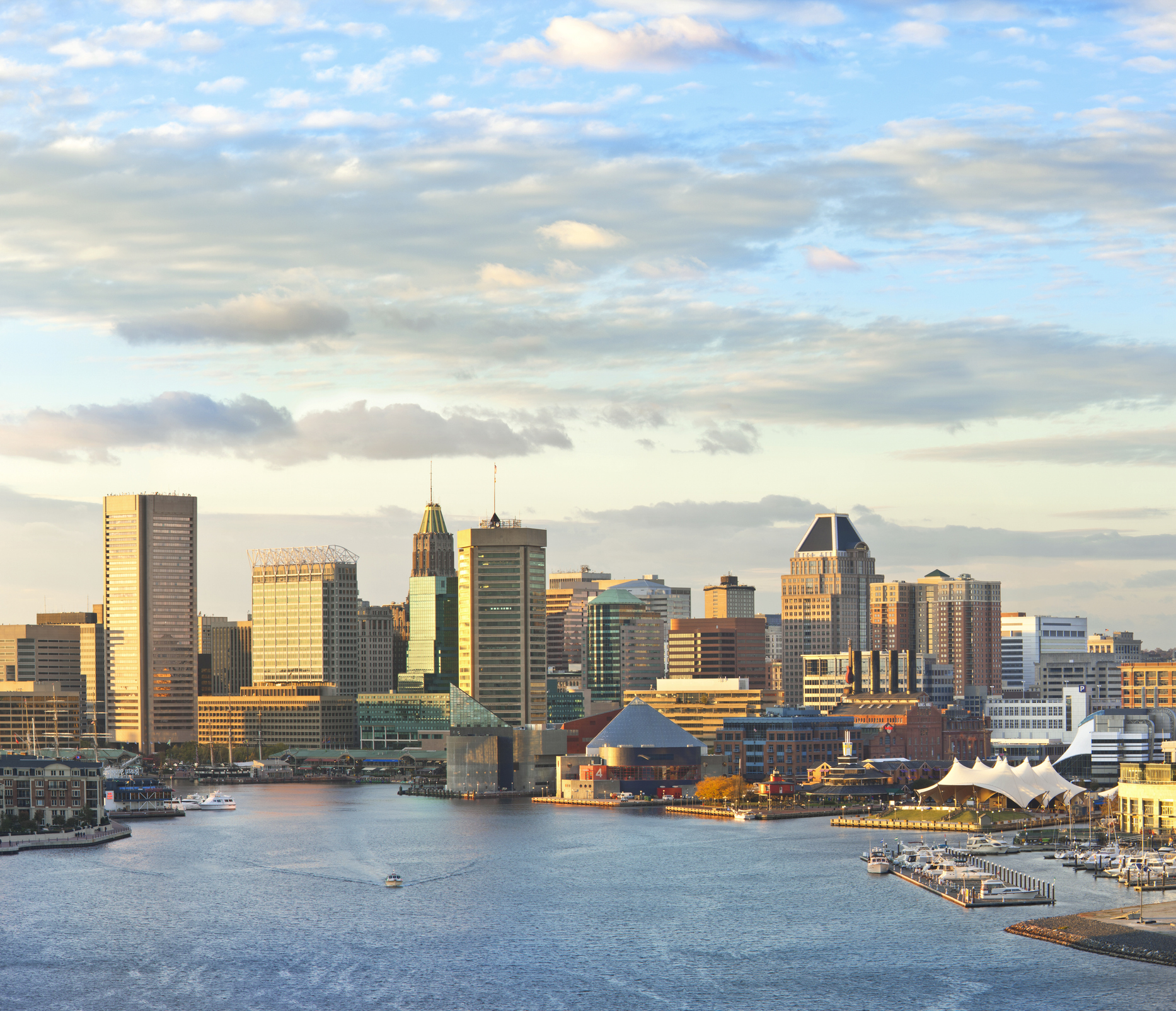 Skyline view of Baltimore, Maryland, featuring the Inner Harbor waterfront and downtown business district at sunset.