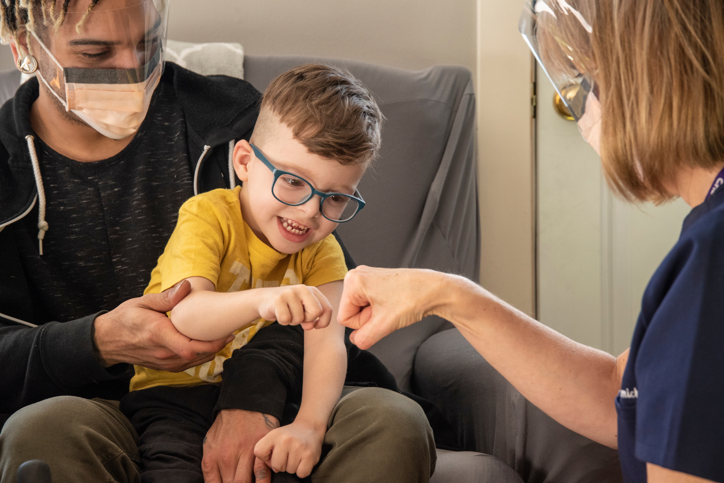 Child patient fist bump with medical worker