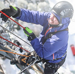 Person climbing cell tower in winter weather