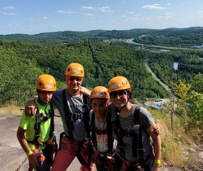 Family on top of mountain smiling 