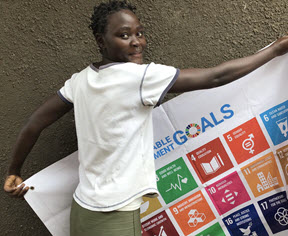 A girl holding a UN goal banner