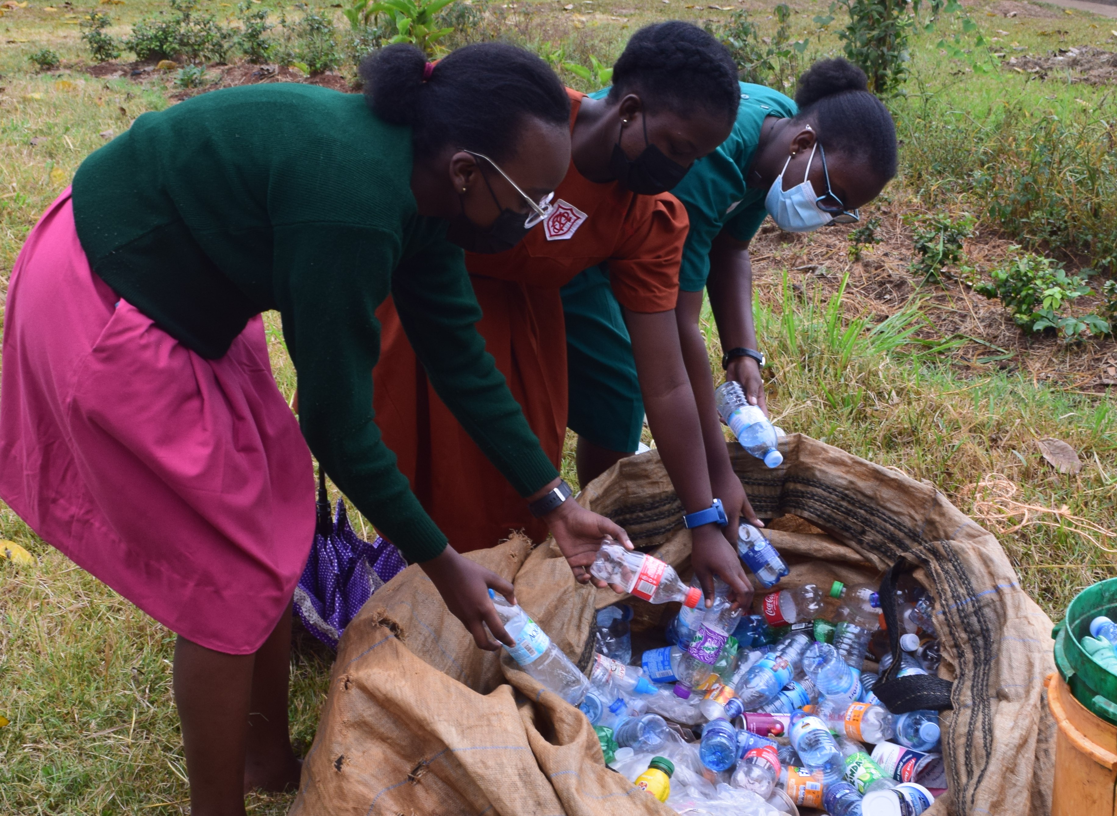 Girls picking up plastic bottles