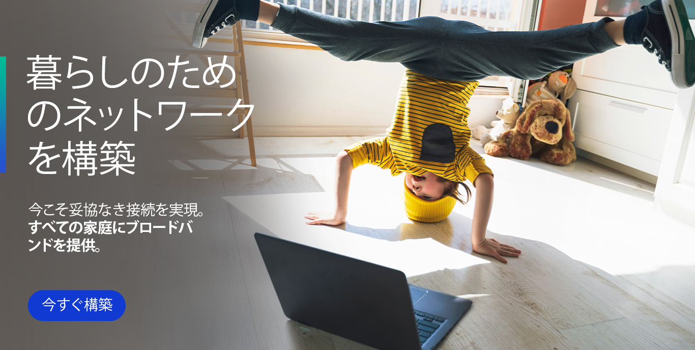 Little boy in yellow striped shirt and hat doing handstand in front of laptop