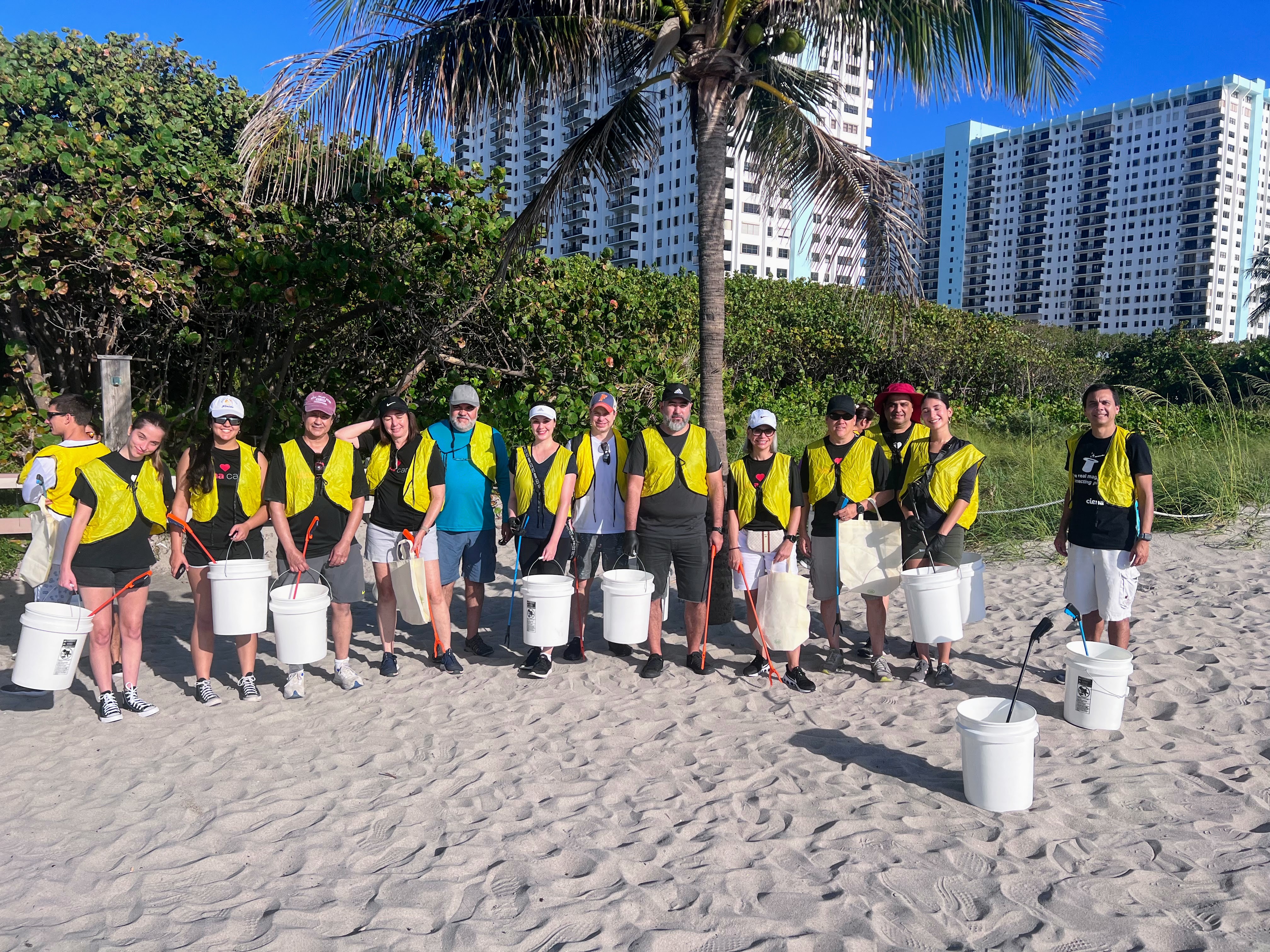 Men and women in cleanup gear on a beach