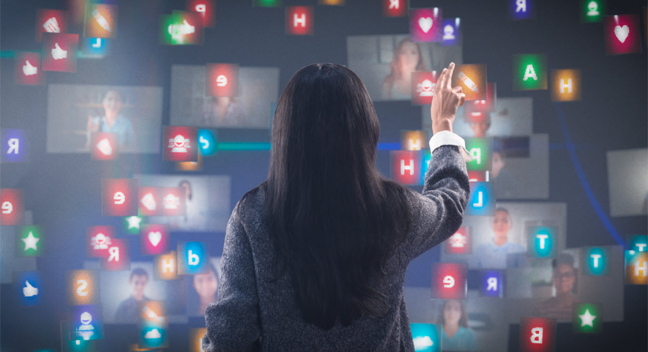 A female teacher in front of a touch screen monitor and touching it